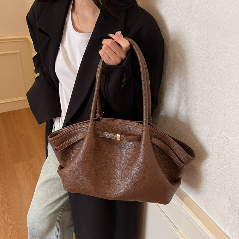 Woman holding a leather shoulder bag